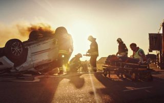 Car accident scene at sunset with ambulance and other first responders