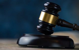 Gavel on a table in front of a blue background