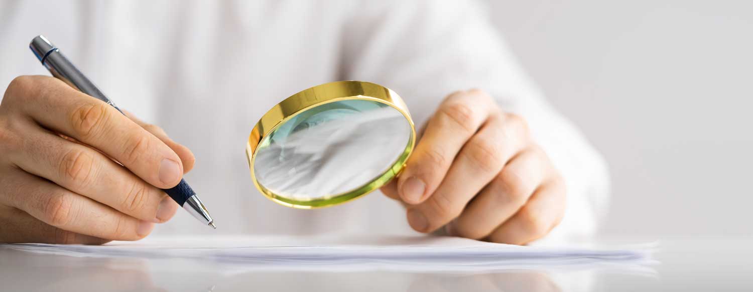Person using magnifying glass to investigate