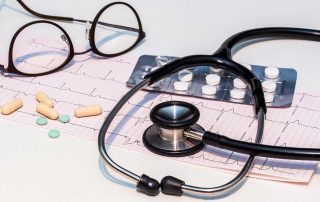 Stethoscope and pills over papers