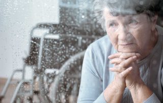 Elderly woman looking through her window praying for help