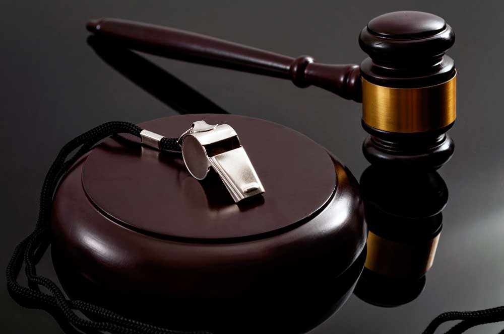 Whistle and gavel on a dark table