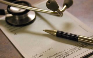 Stethoscope and prescription pad on a table