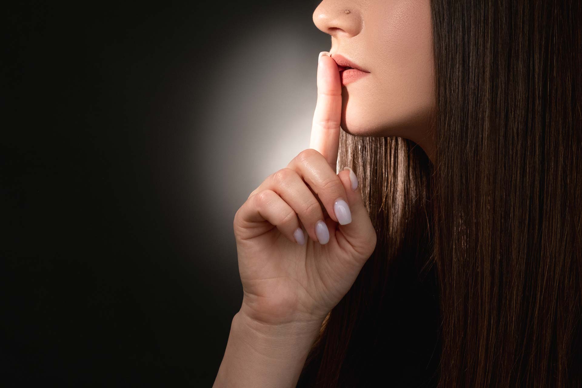 Woman hushing the room with a finger and a whistleblower secret