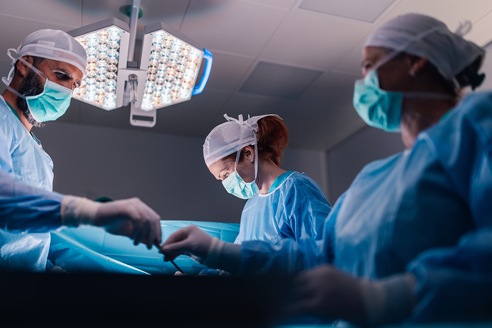 Surgical team collaborates on complex procedure in sterile setting.
